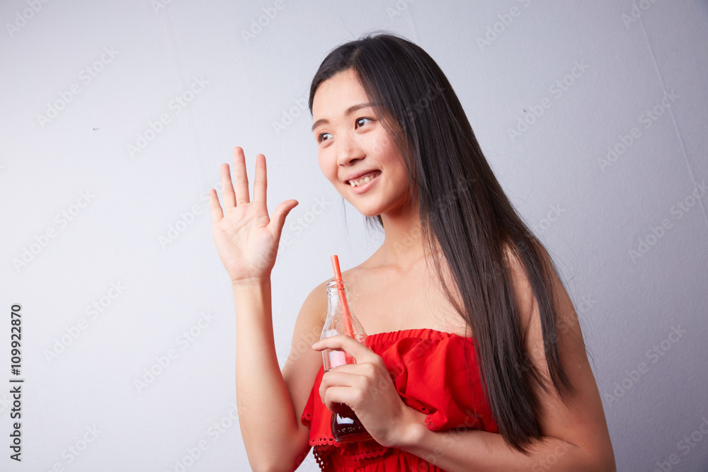Chinese woman drinking carbonated drink through a straw Chinese woman drinking carbonated drink through a straw