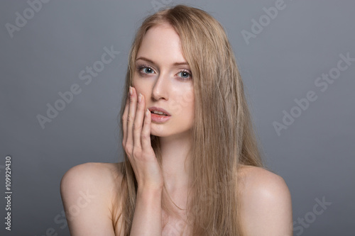 Beauty young woman with wet hair on gray background isolated