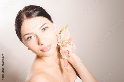 Beautiful lady with lilly flower. Perfect skin.