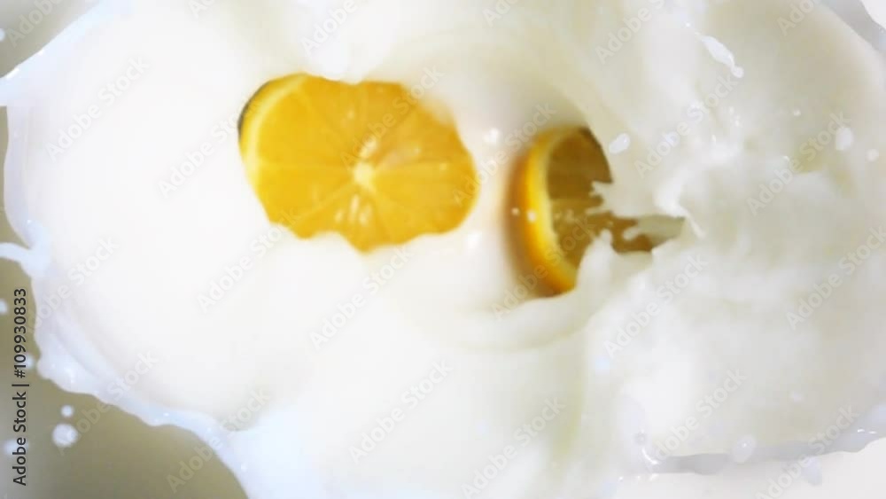 Two tasty fresh oranges halfs fall down into the milk with stunning explosive splash in slow motion. High-speed camera vertical shooting. Two tasty fresh oranges halfs fall down into the milk with stunning explosive splash in slow motion. High-speed camera vertical shooting.