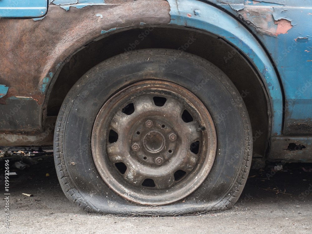 Close up flat tire of old car park on the street