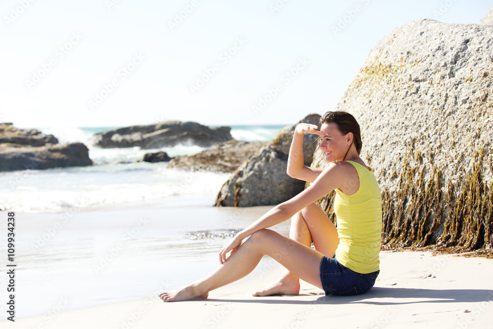 Beautiful young woman sitting on the beach Beautiful young woman sitting on the beach