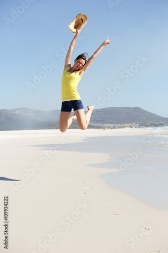 Cheerful young woman jumping at the seashore