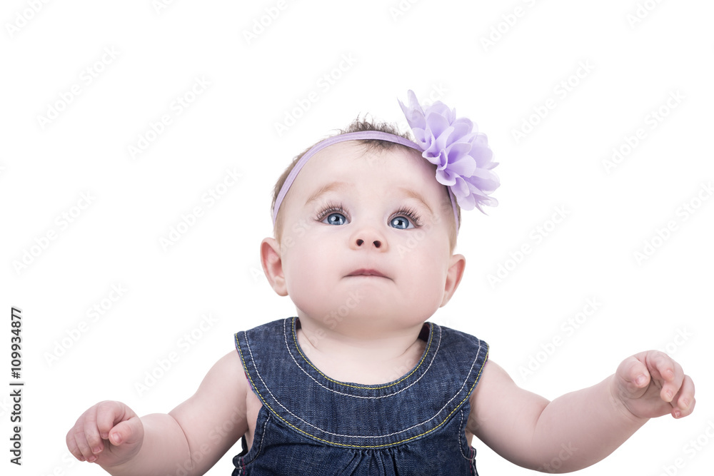 cute baby girl with big blue eyes and long eyelashes. portrait of child on white background, isolated. baby raises his arms up and looking upwards cute baby girl with big blue eyes and long eyelashes. portrait of child on white background, isolated. baby raises his arms up and looking upwards