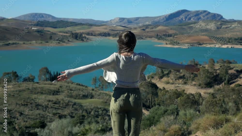 Woman stretching arms and enjoying lake view in country, super slow motion 240fps
