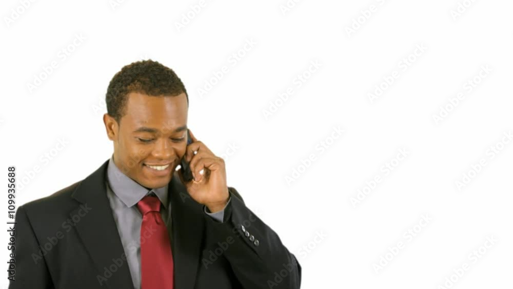 A young African American man in a business suit answers his cell phone then engages in conversation of a positive nature. A young African American man in a business suit answers his cell phone then engages in conversation of a positive nature.