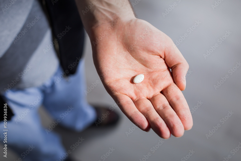 One small pill in palm One small pill in palm