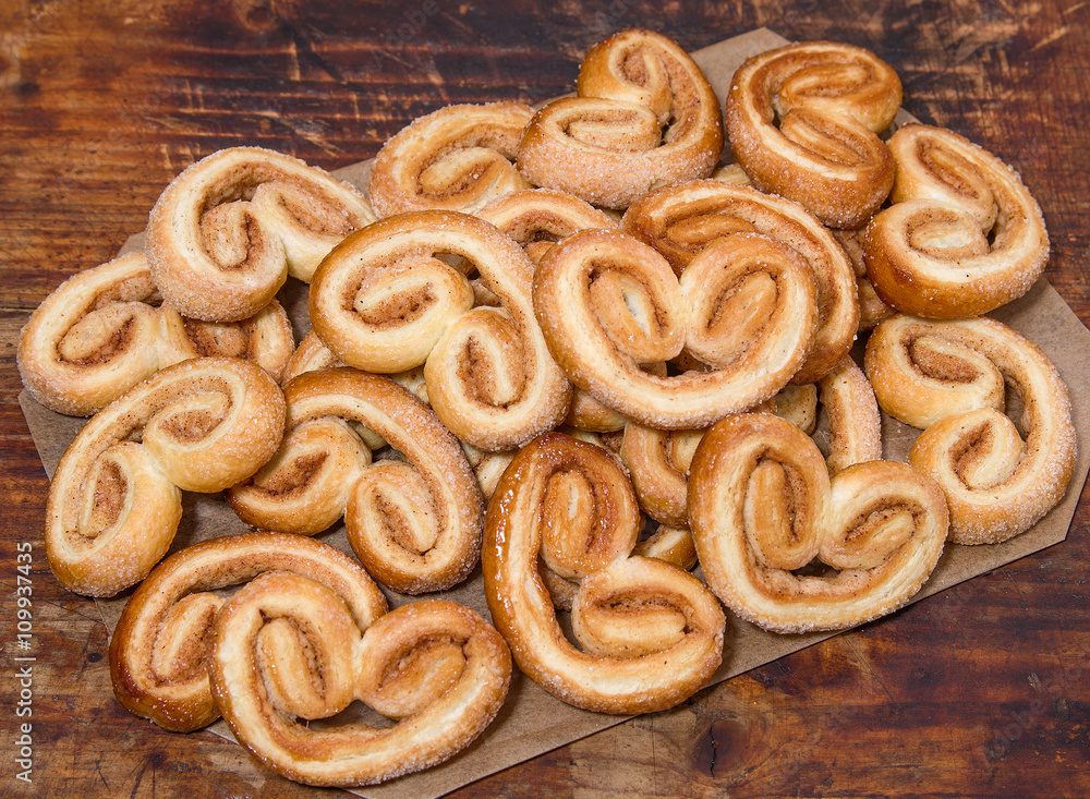Puff sweet pretzels with cinnamon  on the dark brown wooden background