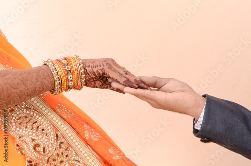 bride and groom joining hands during an indian wedding ritual photo