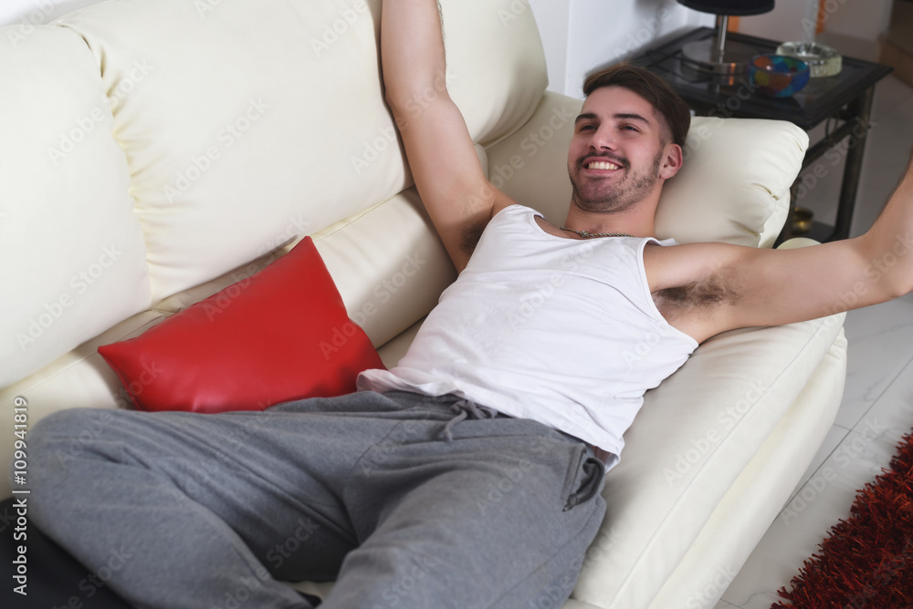 happy young man lying on couch and relaxing happy young man lying on couch and relaxing