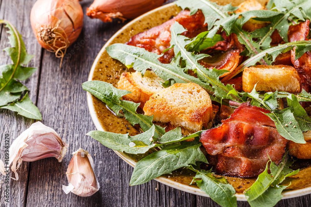 Fresh dandelion salad with fried bacon and garlic croutons. Fresh dandelion salad with fried bacon and garlic croutons.