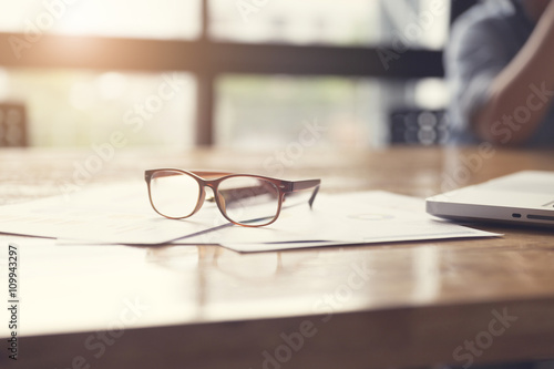 eyeglasses, business document and laptop computer notebook on wo