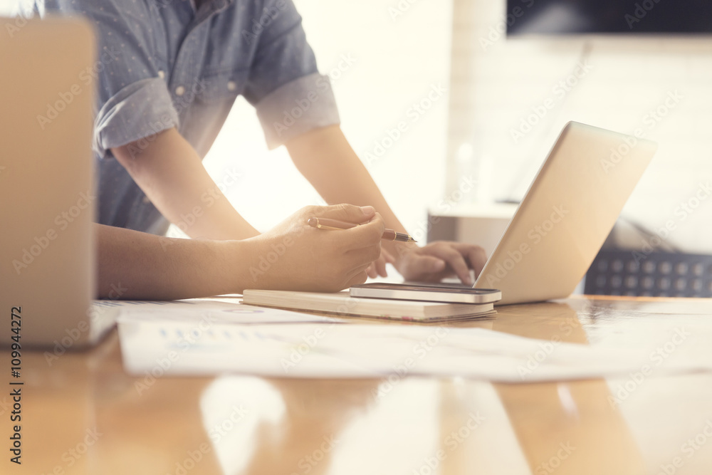 people working with laptop computer and business document