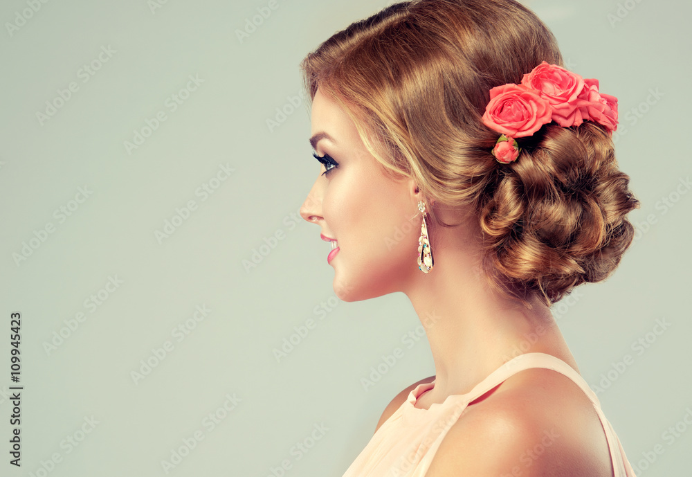 Fototapeta Beautiful model with elegant hairstyle . Beautiful woman with fashion wedding hairstyle with flower roses and colourful makeup