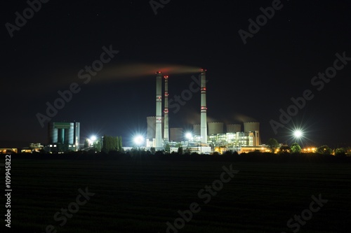 A coal-fired power station in the distance at night. Pocerady, Czech republic