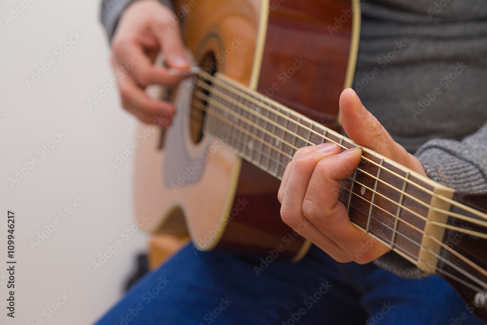 Hände eines jungen Mannes der Gitarre spielt