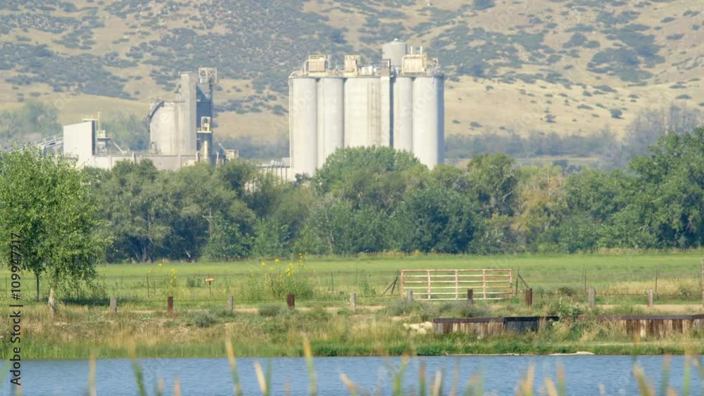 A grain processing plant with a lovely lake in front of it and Colorado mountains in the distance. A grain processing plant with a lovely lake in front of it and Colorado mountains in the distance.