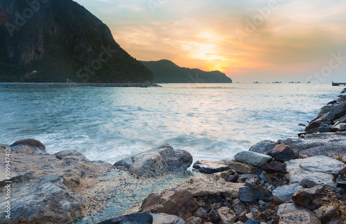 Sunrise over rocky beach and mountain background, natural landscape