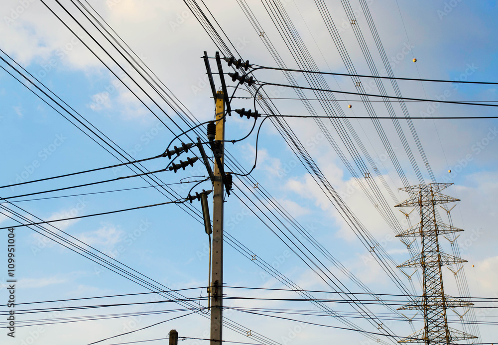 Electrical pole and pylon with many power lines, against blue sk Electrical pole and pylon with many power lines, against blue sk