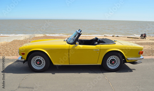 Fotografie Classic Yellow Triumph TR6 on the seafront at Felixstowe.