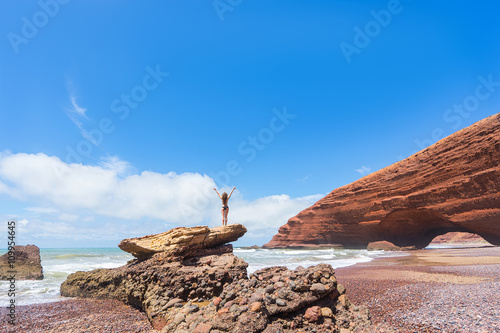 Woman in bikini on rock. Legzira beach, Morocco.