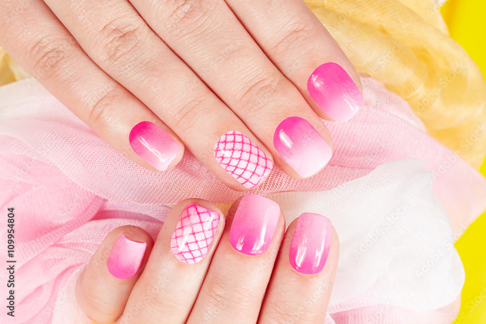 Hands with manicured nails covered with pink nail polish 