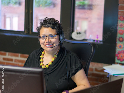 Middle Aged Hispanic Female In Office Environment Wearing Headph photo