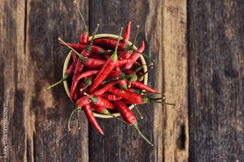 Red Hot Chili Peppers in a cup on old wooden background