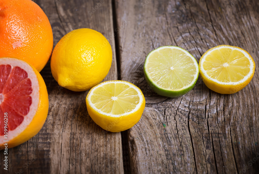 Halves of citrus fruits on wooden background. Orange, grapefruit Halves of citrus fruits on wooden background. Orange, grapefruit