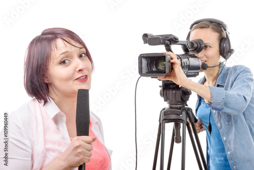 young woman journalist with a microphone and camerawoman