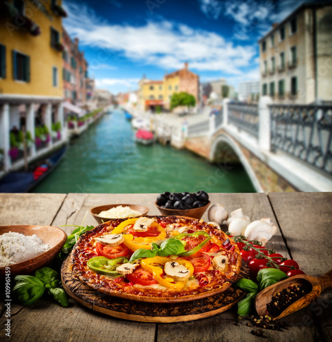 Rustic pizza with old city Italy background © Jag_cz