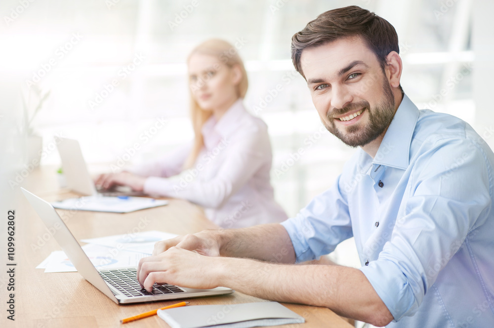 Attractive young guy is using a laptop Attractive young guy is using a laptop