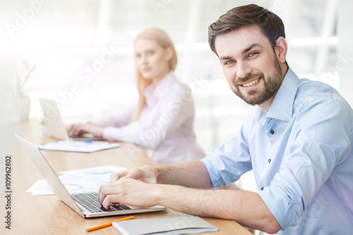 Attractive young guy is using a laptop