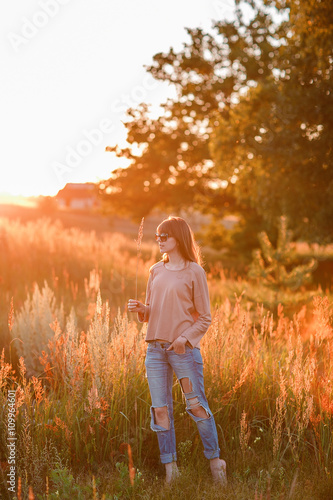 young modern girl on background sunset.  © malkovkosta