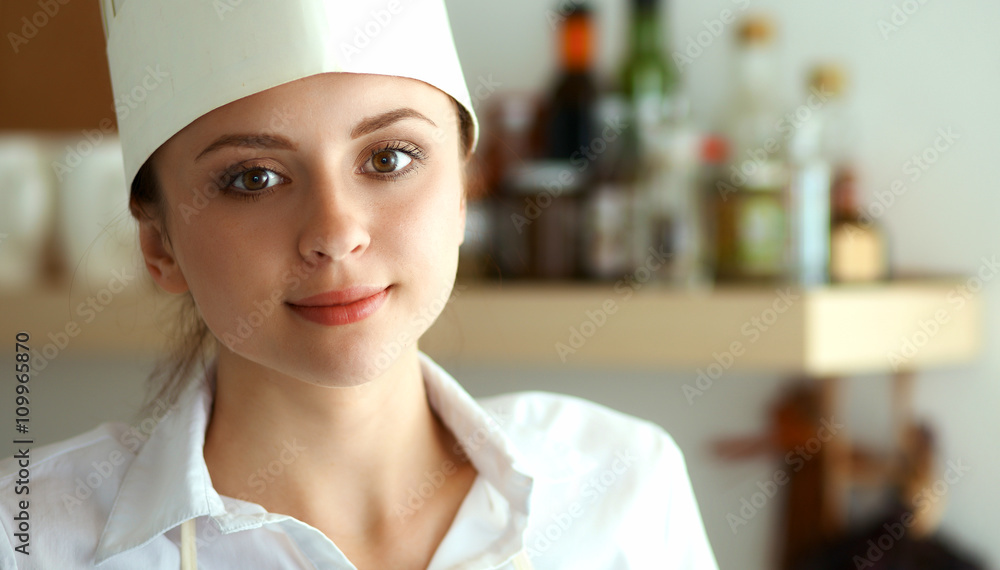 Chef woman portrait with uniform in the kitchen Chef woman portrait with uniform in the kitchen