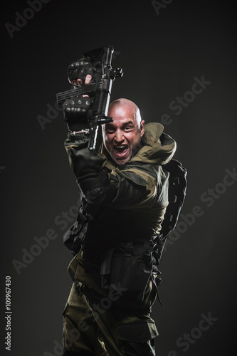 soldier man hold Machine gun on a  dark background © sheikoevgeniya