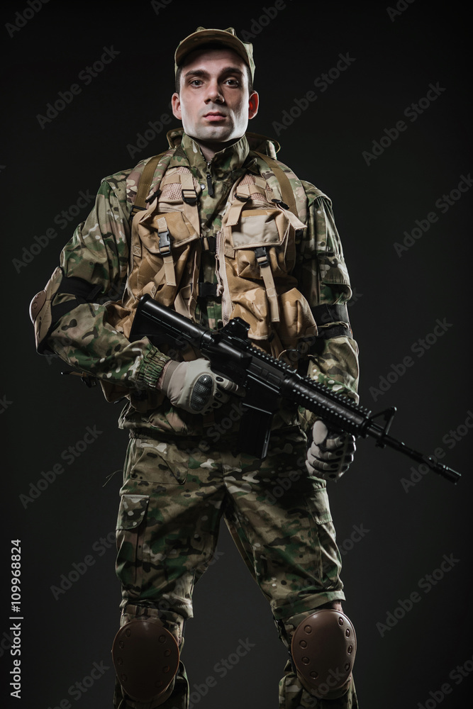 Soldier man hold Machine gun on a dark background Soldier man hold Machine gun on a dark background