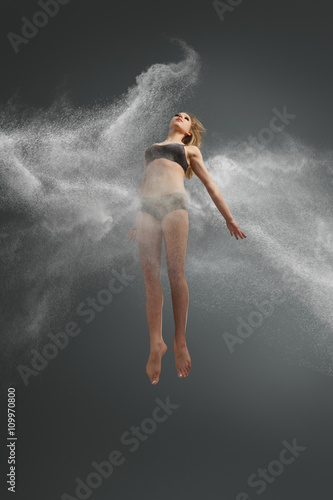 Dancer jumping into white powder cloud