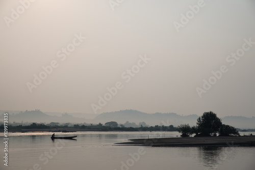 Lonely fisherman on boat with fog background, the Mekong River in Thailand.