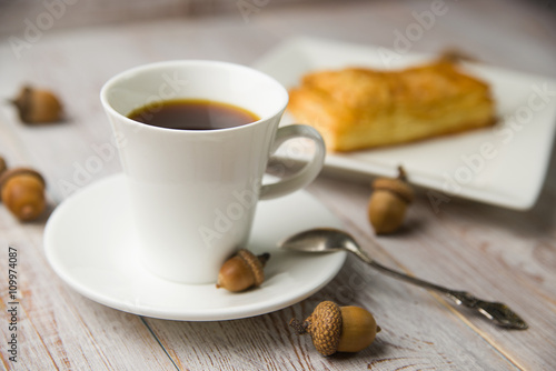 Cup of coffee, sweet buns and acorns