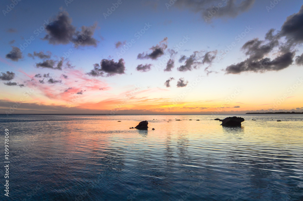 Sunset over a few rocks in the ocean on Eleuthera (Bahamas)