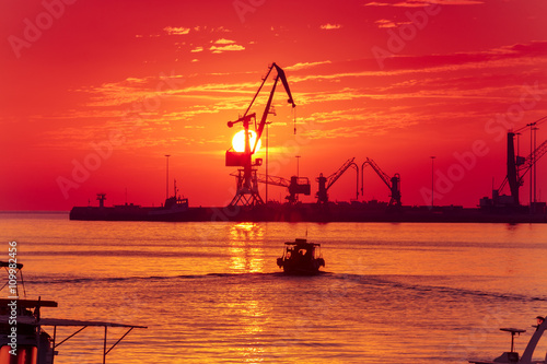 Cranes in sea cargo port of Heraklion on the background of the rising sun, Cr...