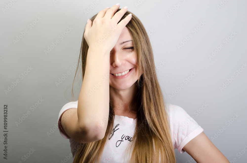 Fototapeta premium Cute, young woman smiling do facepalm
