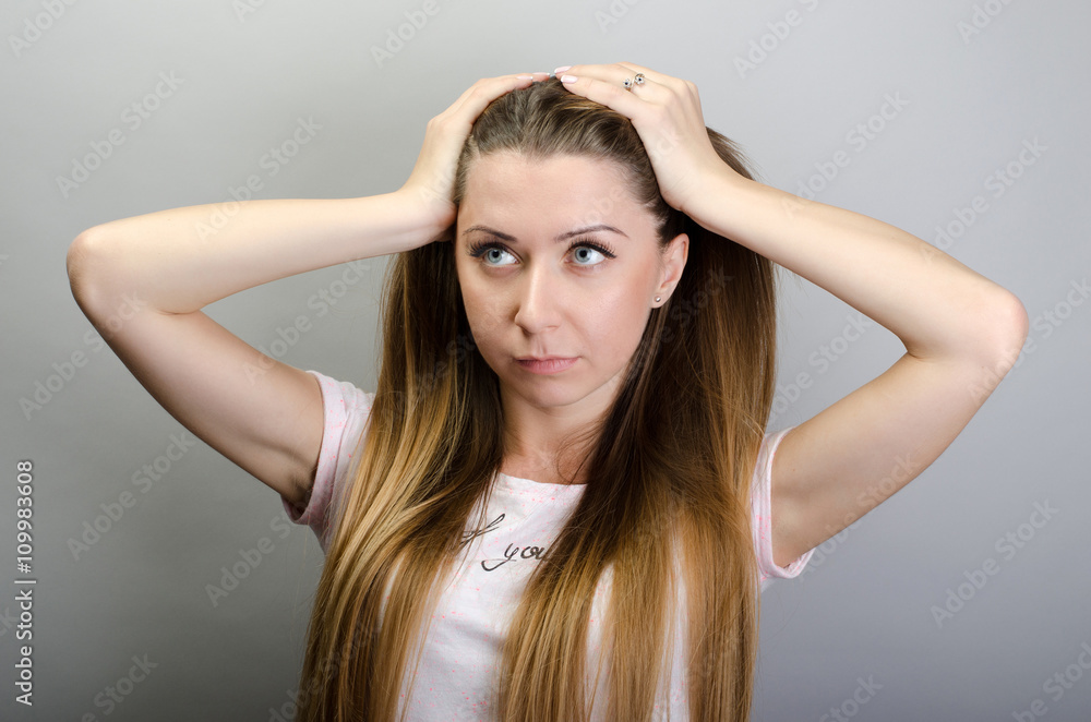 Young woman holding her hand to the head