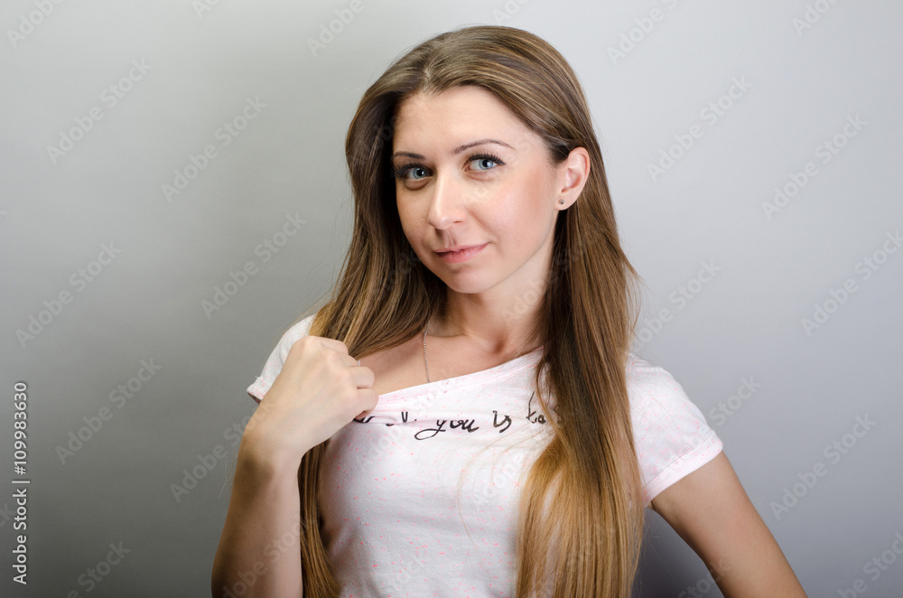 Woman pulls shirt. On a gray background. Woman pulls shirt. On a gray background.