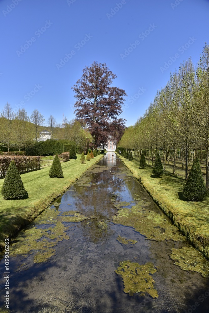 Le canal inférieur des Jardins d'Eau d'Annevoie au printemps au milieu de la verdure luxuriante 
