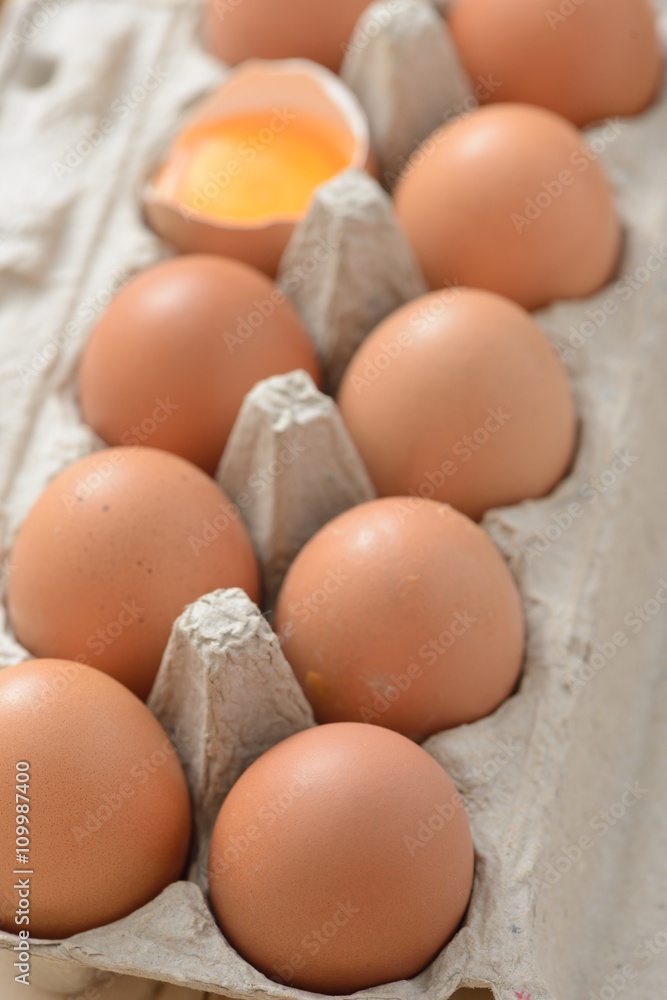 brown eggs in carton with an open egg brown eggs in carton with an open egg