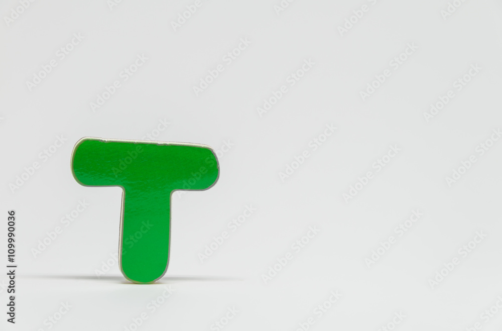 Green wooden alphabet T with white background and selective focus Green wooden alphabet T with white background and selective focus