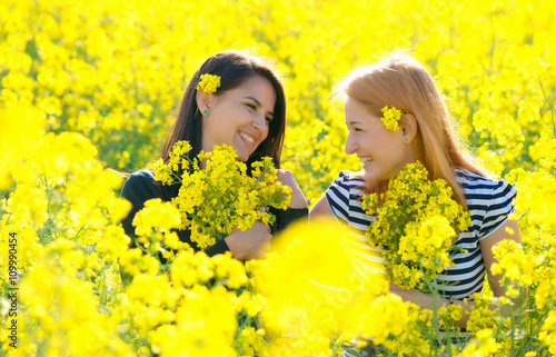 two beautiul girls having fun in the colza field