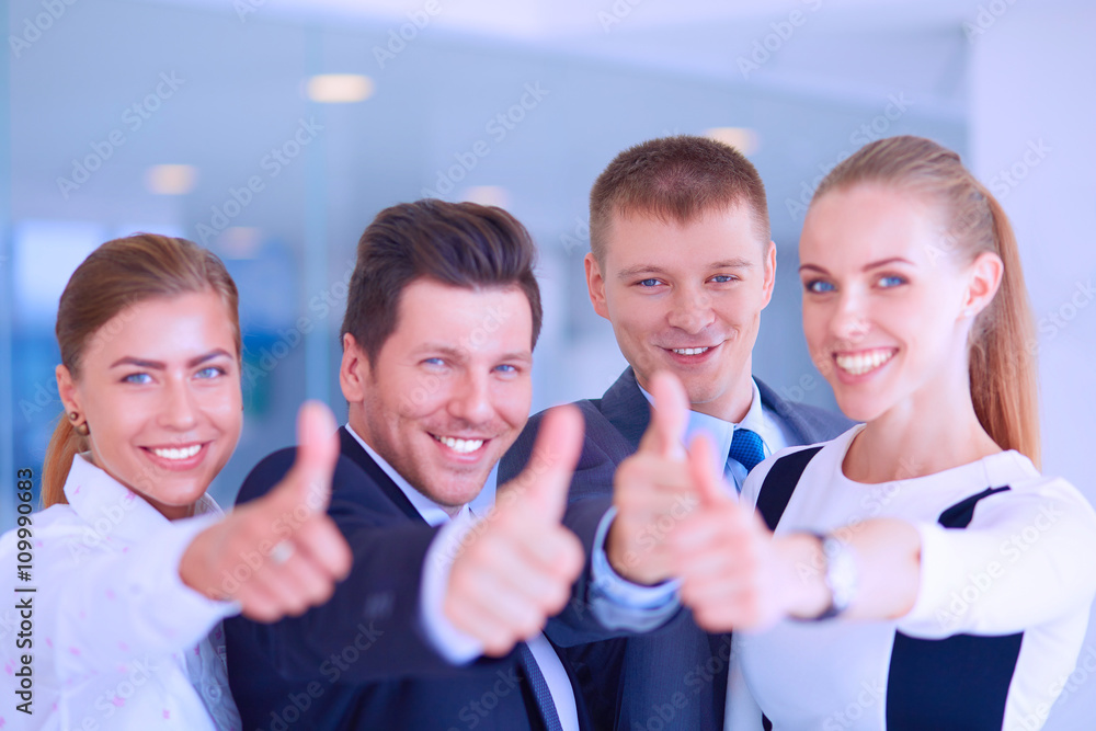 Happy business team showing thumbs up in office Happy business team showing thumbs up in office